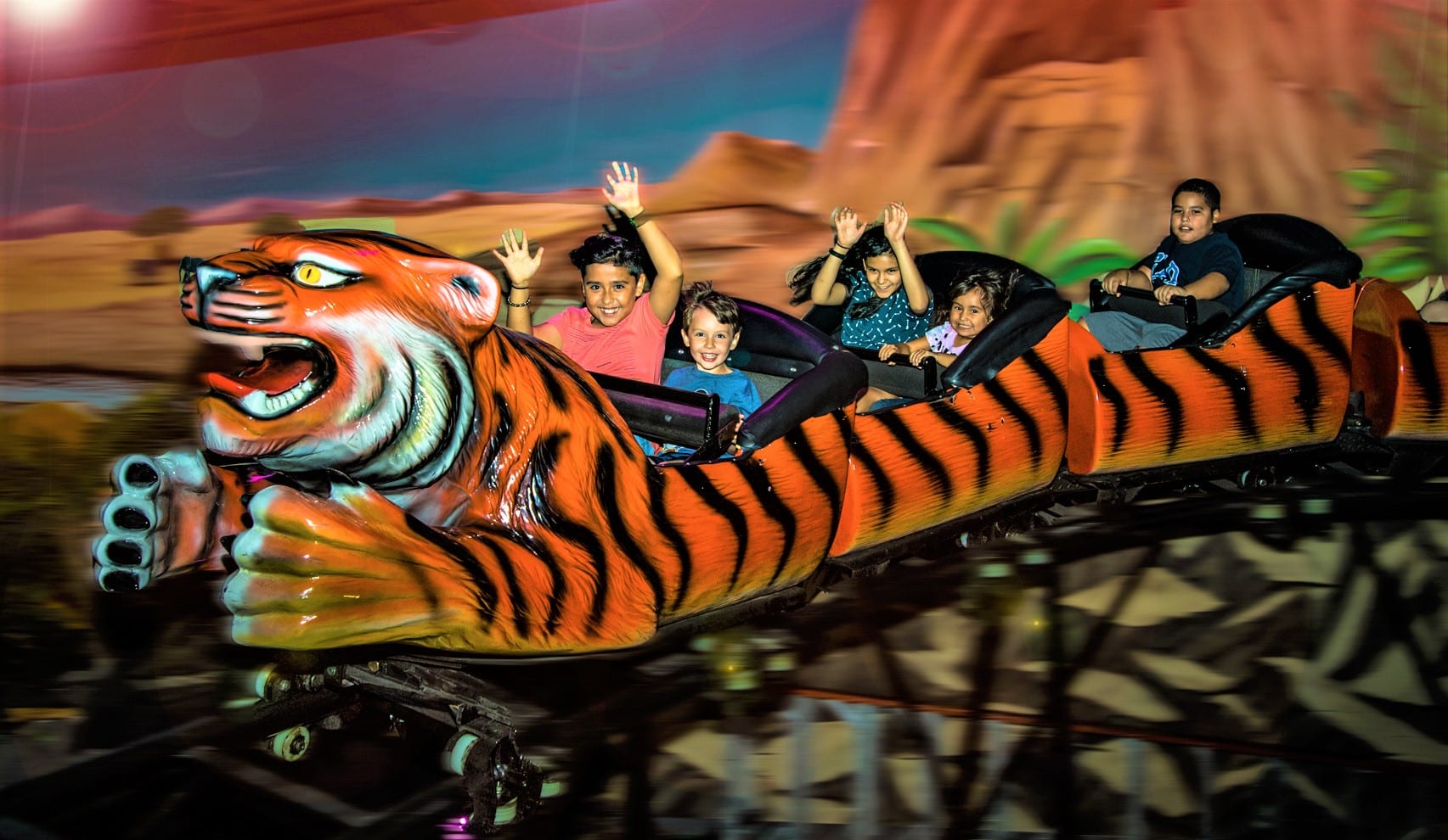 A group of people riding on the back of a tiger roller coaster.